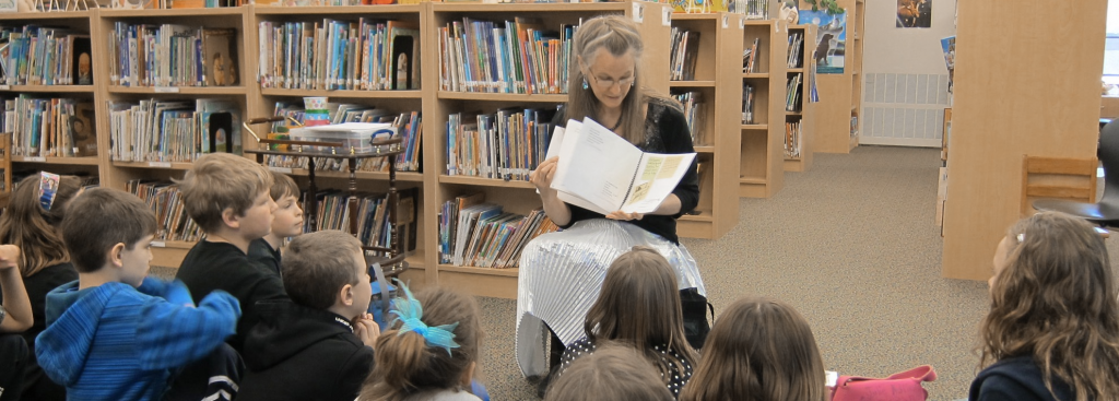 Debra Fraser reads to children in school library