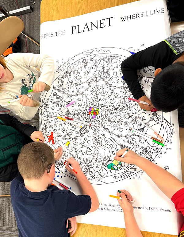 Students coloring in PLANET mural